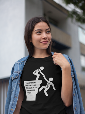 “Savior lifting Saved at cliff with Romans 10:13 verse—Christian graphic tee, white artwork on black background.”